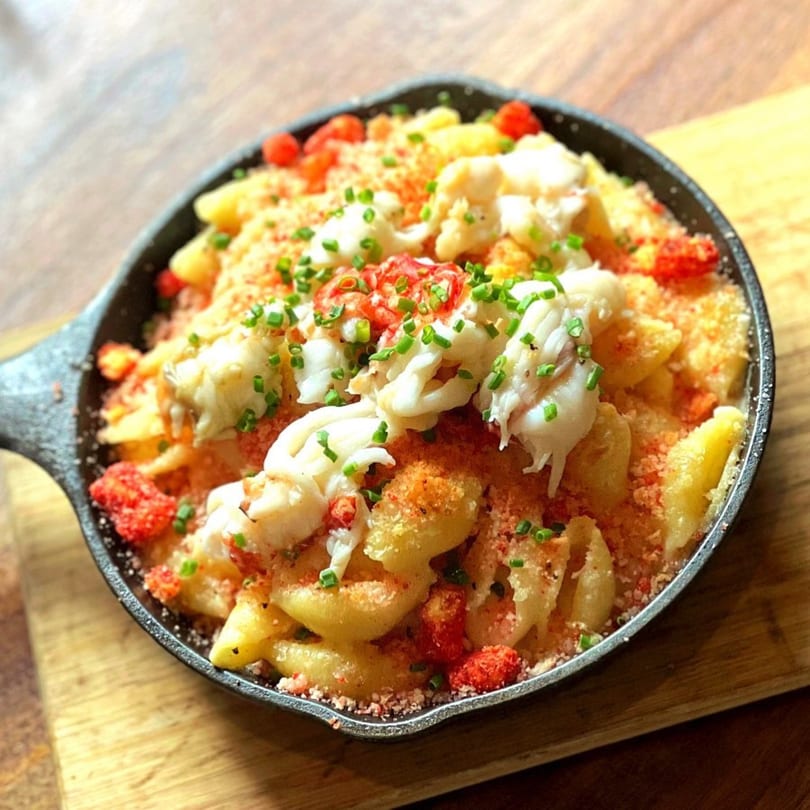 Butcher Bar's lobster mac and cheese, topped with chives and red pepper flakes, in a cast iron skillet.